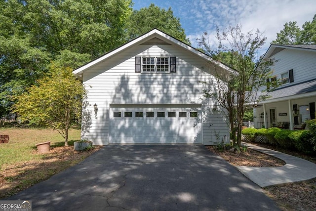 view of front of home featuring asphalt driveway and a detached garage