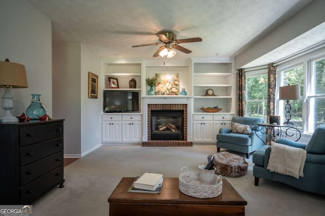 living room featuring carpet flooring, a ceiling fan, a fireplace, a textured ceiling, and baseboards