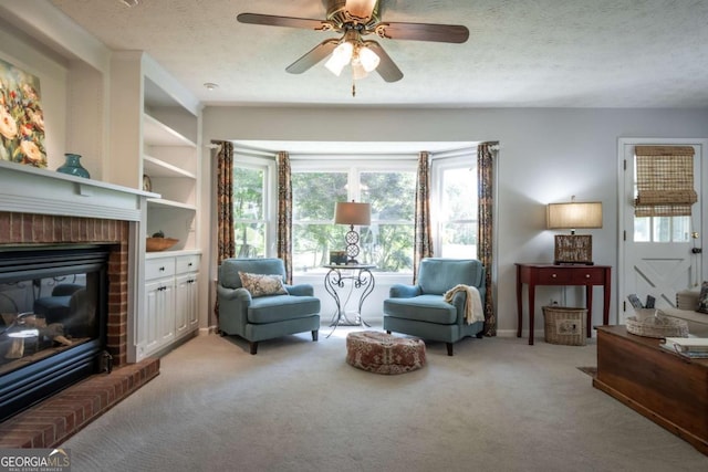 living area with light carpet, a ceiling fan, a textured ceiling, and a brick fireplace