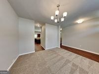620 Sedona Loop, Hampton, GA 30228 - carpeted empty room featuring baseboards and a chandelier