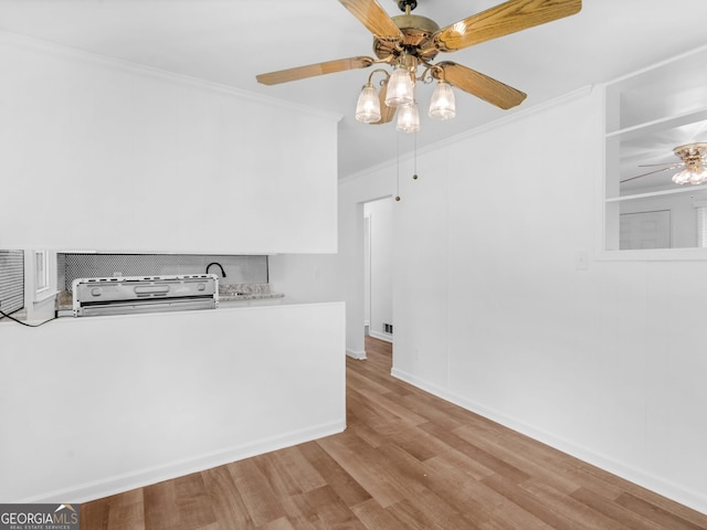 unfurnished room featuring ceiling fan, ornamental molding, wood finished floors, and baseboards