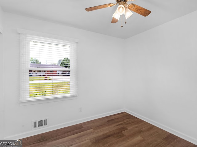spare room featuring dark wood-style flooring, baseboards, and a ceiling fan