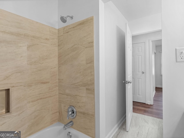 full bathroom featuring shower / tub combination, marble look tiles, and baseboards