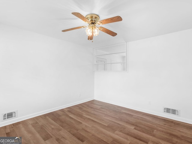 spare room with ceiling fan, wood finished floors, and baseboards