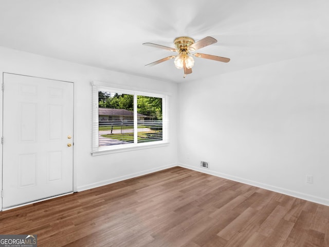 unfurnished room featuring wood finished floors, ceiling fan, and baseboards