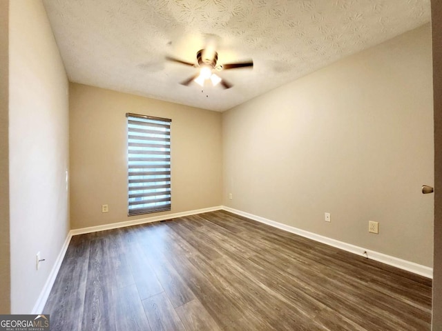 empty room featuring ceiling fan, dark wood-style floors, baseboards, and a textured ceiling