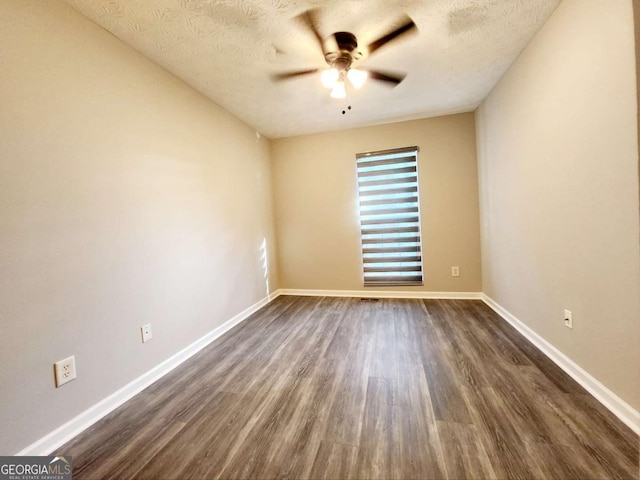 unfurnished room featuring ceiling fan, dark wood-style flooring, a textured ceiling, and baseboards