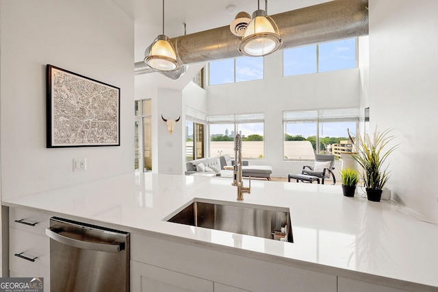 260N 18th St Unit 10326, Atlanta, GA 30363 - kitchen with stainless steel dishwasher, a towering ceiling, white cabinets, light countertops, and open floor plan