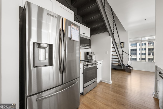 260N 18th St Unit 10326, Atlanta, GA 30363 - kitchen with appliances with stainless steel finishes, light wood-type flooring, white cabinets, and light countertops