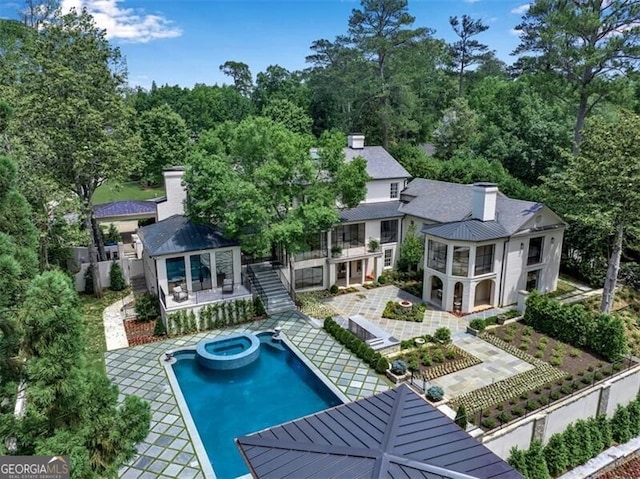 3625 Tuxedo Rd NW, Atlanta, GA 30305 - back of property featuring a balcony, a patio, a chimney, a pool with connected hot tub, and a standing seam roof