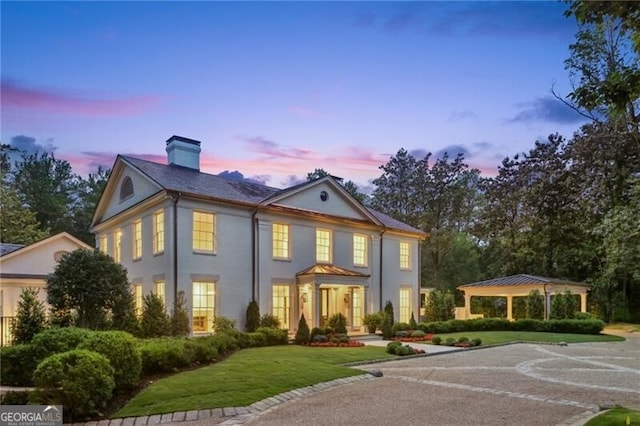 3625 Tuxedo Rd NW, Atlanta, GA 30305 - view of front facade with a gazebo, a chimney, a front yard, stucco siding, and uncovered parking