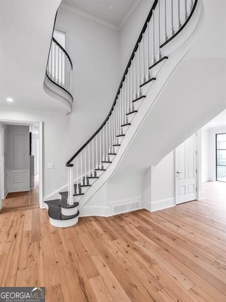 3625 Tuxedo Rd NW, Atlanta, GA 30305 - staircase featuring hardwood / wood-style flooring, a high ceiling, ornamental molding, baseboards, and recessed lighting