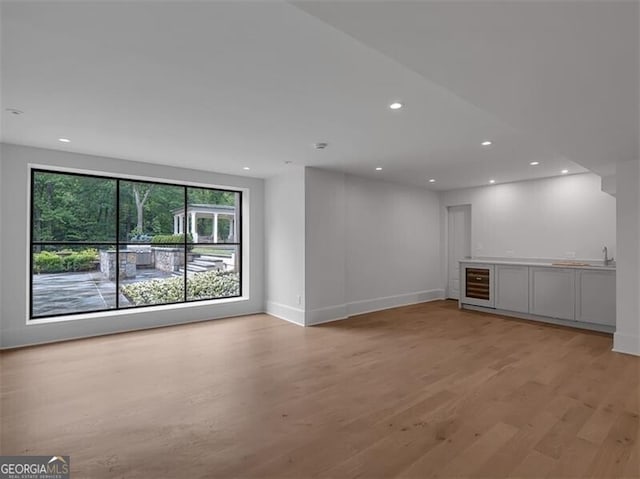 3625 Tuxedo Rd NW, Atlanta, GA 30305 - spare room with beverage cooler, light wood-type flooring, recessed lighting, baseboards, and a sink