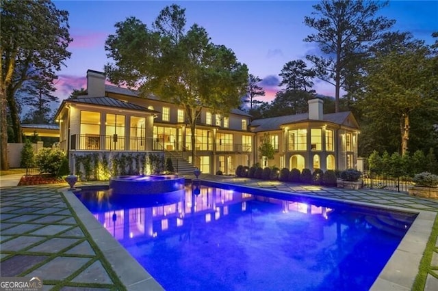 3625 Tuxedo Rd NW, Atlanta, GA 30305 - rear view of house featuring a chimney, a pool with connected hot tub, a standing seam roof, a gazebo, and metal roof