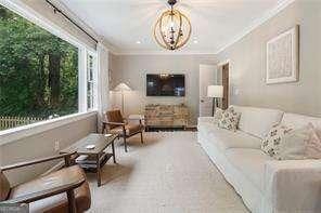 living area featuring ornamental molding and a chandelier