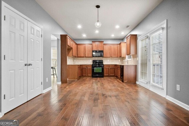 456 Crestmont Ln, Canton, GA 30114 - kitchen with black appliances, tasteful backsplash, wood-type flooring, brown cabinetry, and light countertops