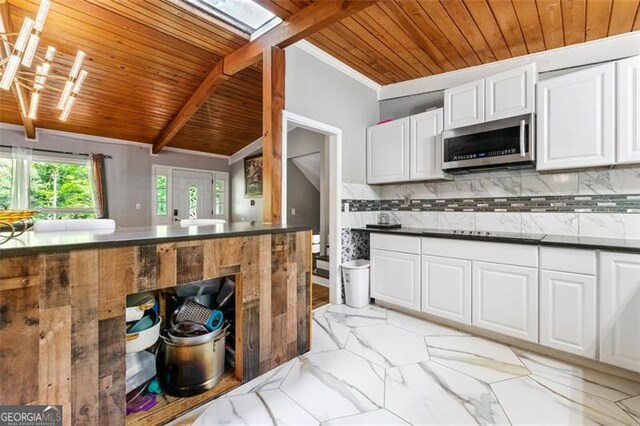 4882 Rock Haven Dr SW, Lilburn, GA 30047 - kitchen featuring stainless steel microwave, wooden ceiling, white cabinetry, light marble finish flooring, and tasteful backsplash