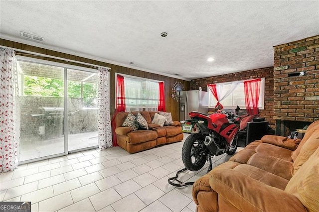 4882 Rock Haven Dr SW, Lilburn, GA 30047 - living area featuring light tile patterned flooring, a textured ceiling, crown molding, and brick wall