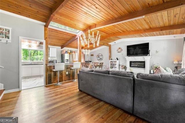 4882 Rock Haven Dr SW, Lilburn, GA 30047 - living room with wood ceiling, light wood-type flooring, a glass covered fireplace, baseboards, and a chandelier