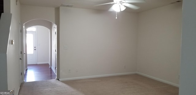 2102 Executive Dr, Duluth, GA 30096 - empty room with arched walkways, ceiling fan, carpet flooring, and baseboards