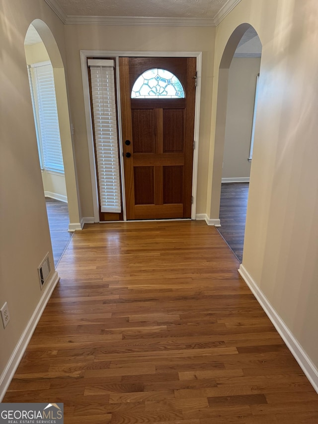 143 Tracy Ln, Mcdonough, GA 30253 - foyer entrance featuring arched walkways, wood finished floors, ornamental molding, and baseboards