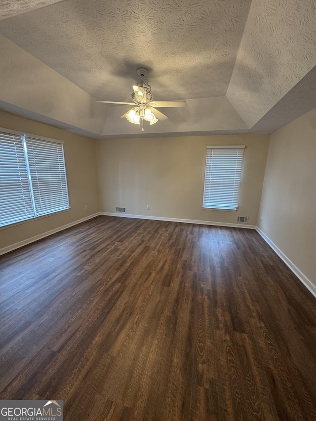 143 Tracy Ln, Mcdonough, GA 30253 - unfurnished room with dark wood-type flooring, a textured ceiling, lofted ceiling, a ceiling fan, and baseboards
