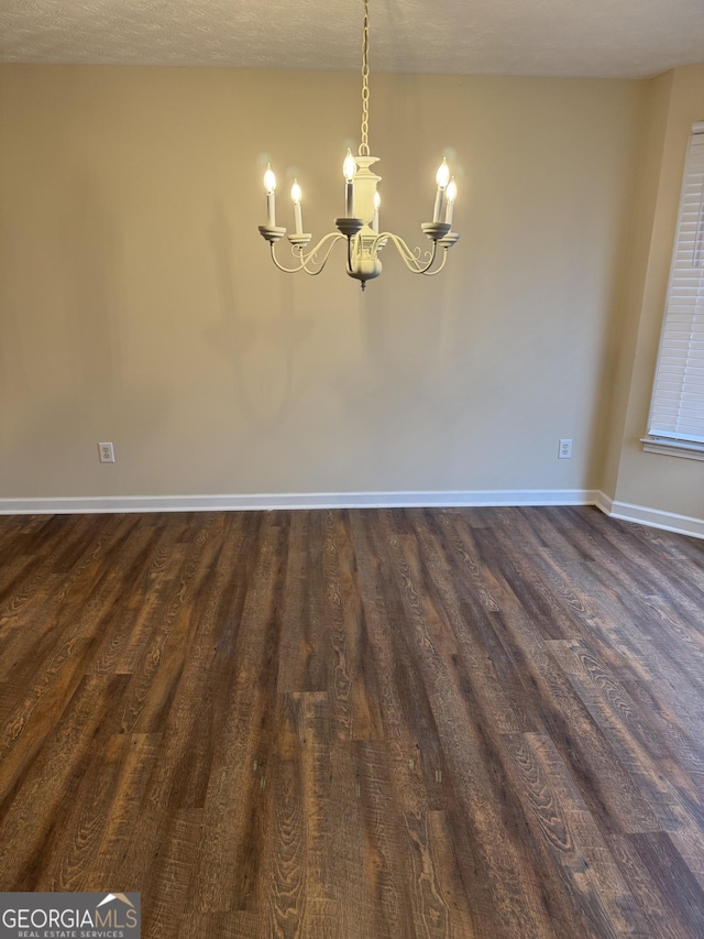 143 Tracy Ln, Mcdonough, GA 30253 - unfurnished dining area with a chandelier, dark wood-style flooring, and baseboards