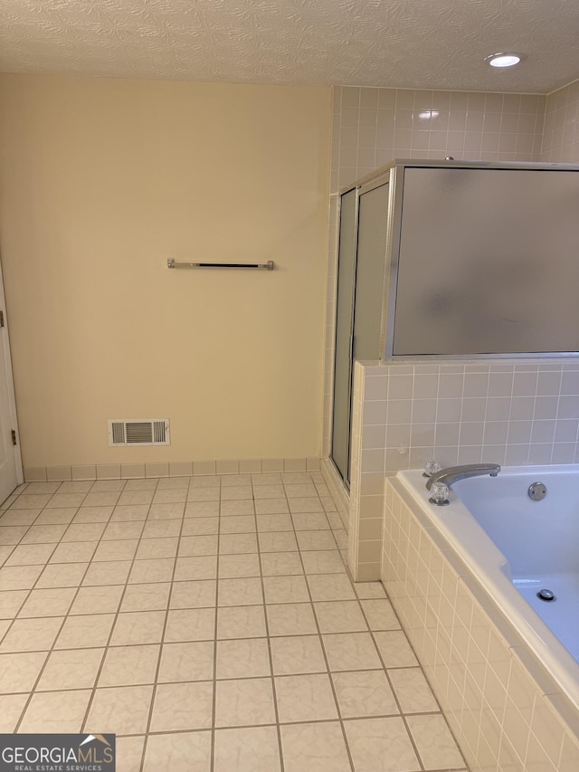 143 Tracy Ln, Mcdonough, GA 30253 - bathroom with a textured ceiling, a shower with door, a bath, and tile patterned flooring