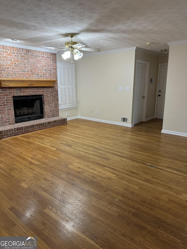 143 Tracy Ln, Mcdonough, GA 30253 - unfurnished living room featuring a textured ceiling, wood finished floors, ornamental molding, baseboards, and a fireplace