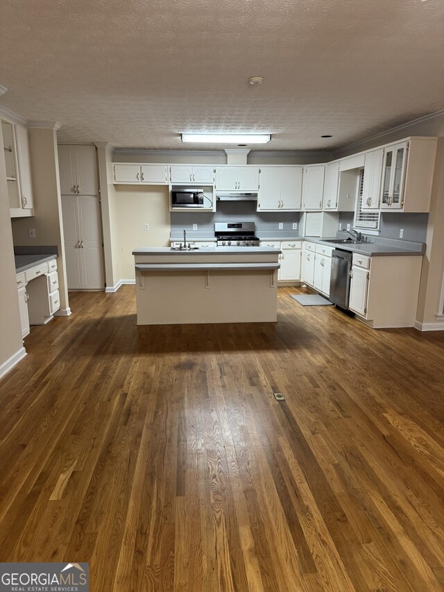 143 Tracy Ln, Mcdonough, GA 30253 - kitchen featuring stainless steel appliances, a sink, dark wood-type flooring, white cabinetry, and under cabinet range hood