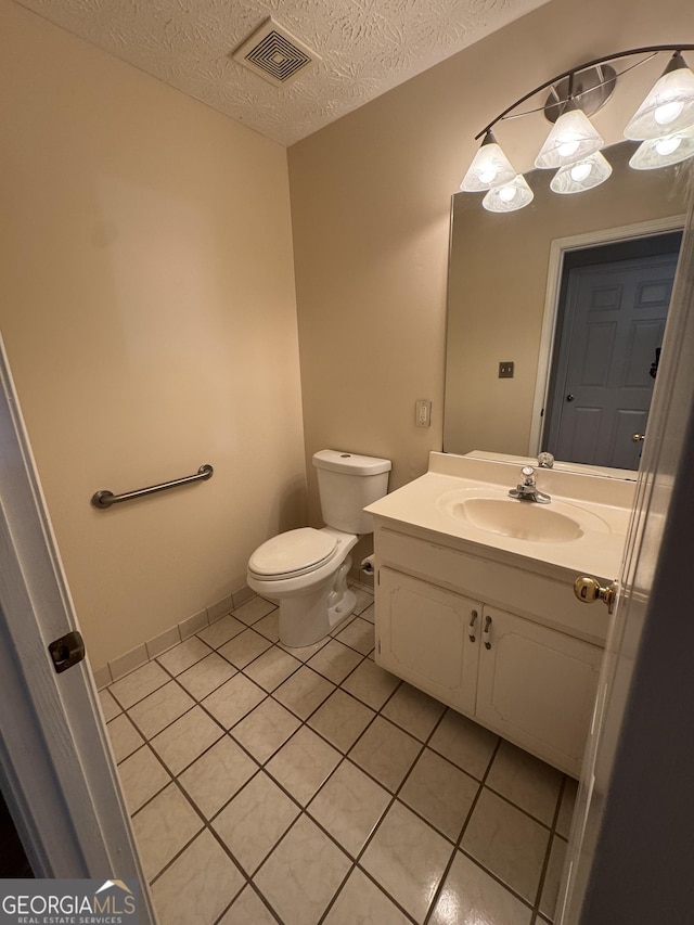 143 Tracy Ln, Mcdonough, GA 30253 - bathroom featuring tile patterned flooring, toilet, vanity, and a textured ceiling