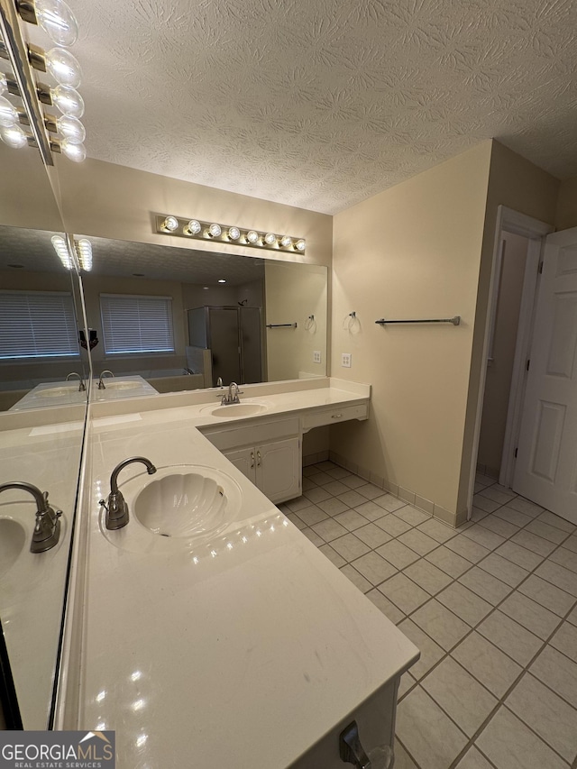143 Tracy Ln, Mcdonough, GA 30253 - full bathroom featuring tile patterned floors, a shower stall, double vanity, a textured ceiling, and baseboards