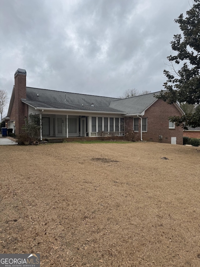 143 Tracy Ln, Mcdonough, GA 30253 - back of house with a chimney, brick siding, and a lawn