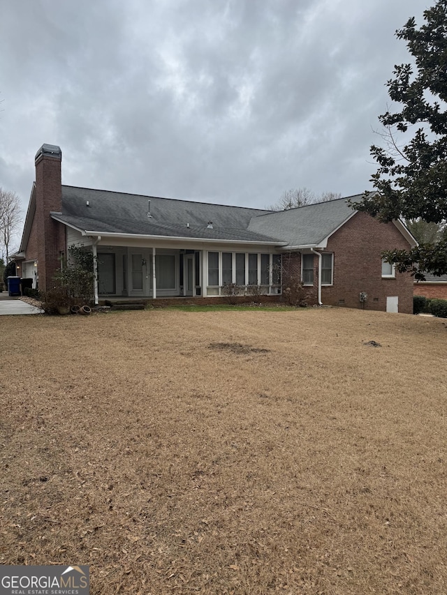 143 Tracy Ln, Mcdonough, GA 30253 - rear view of house with a chimney, brick siding, and a lawn