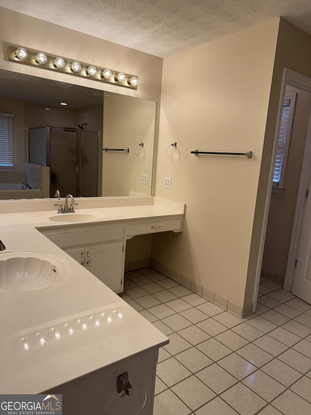 143 Tracy Ln, Mcdonough, GA 30253 - bathroom featuring tile patterned floors, a shower stall, double vanity, baseboards, and a textured ceiling