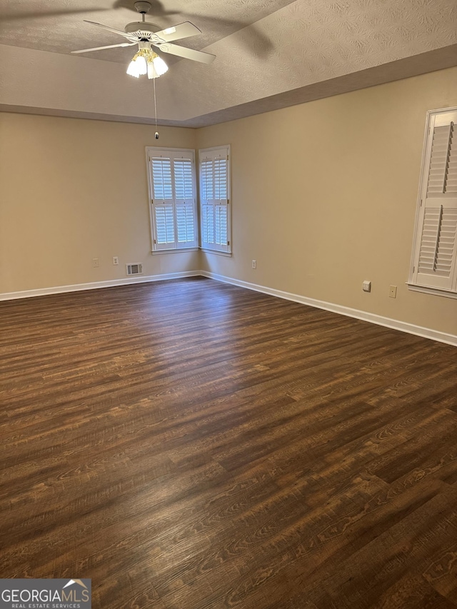 143 Tracy Ln, Mcdonough, GA 30253 - spare room featuring a ceiling fan, a textured ceiling, dark wood-style floors, and baseboards