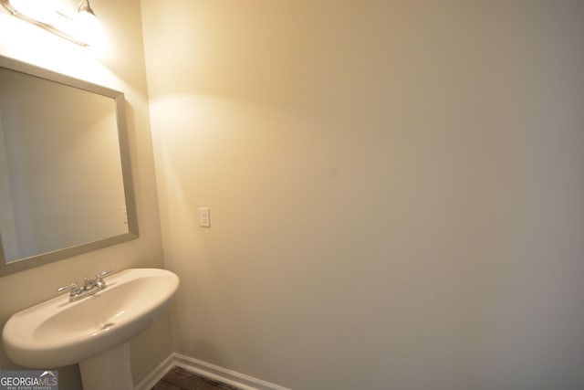 1560 Iris Walk, Jonesboro, GA 30238 - bathroom featuring a sink, baseboards, and wood finished floors