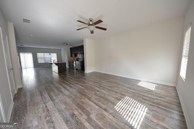 1560 Iris Walk, Jonesboro, GA 30238 - unfurnished living room with a ceiling fan, wood finished floors, and baseboards