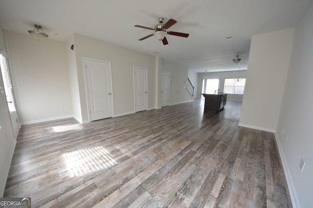 1560 Iris Walk, Jonesboro, GA 30238 - unfurnished living room with stairway, ceiling fan, wood finished floors, and baseboards