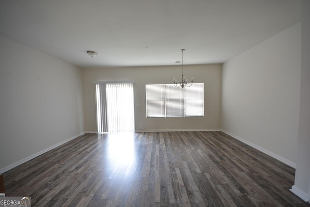 1560 Iris Walk, Jonesboro, GA 30238 - spare room featuring a chandelier, dark wood-style flooring, and baseboards