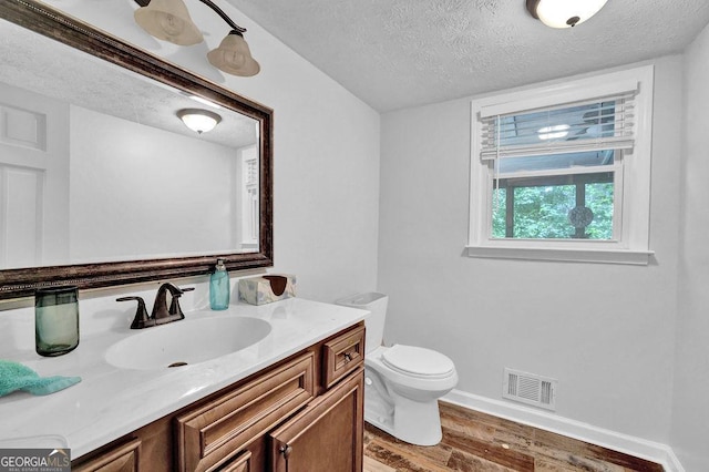 1315 Arden Dr SW, Marietta, GA 30008 - half bathroom featuring a textured ceiling, wood finished floors, toilet, vanity, and baseboards