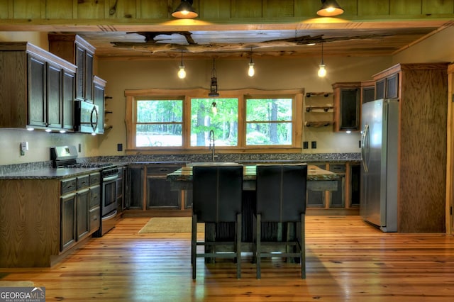 179 Huckleberry Ln, Ellijay, GA 30536 - kitchen with stainless steel appliances, dark countertops, light wood finished floors, open shelves, and a sink