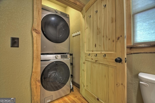 179 Huckleberry Ln, Ellijay, GA 30536 - clothes washing area featuring stacked washer / dryer, a textured wall, and wood finished floors