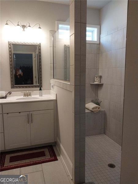 116 Four Seasons Blvd, Dallas, GA 30132 - bathroom with tile patterned floors, vanity, and tiled shower