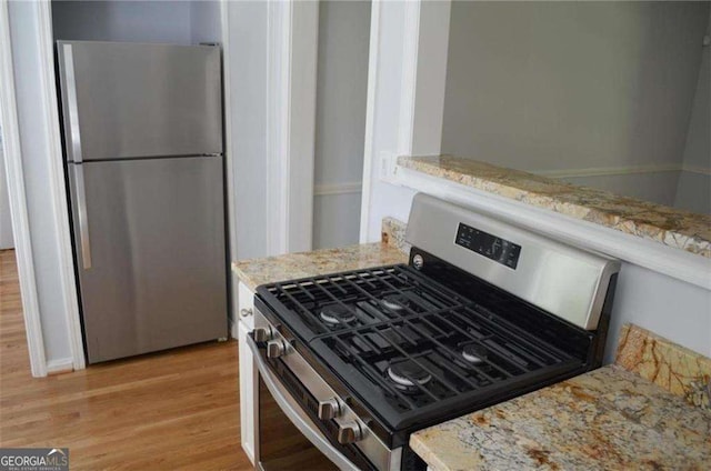 2381 Eastway Rd, Decatur, GA 30033 - kitchen with appliances with stainless steel finishes, light wood-style flooring, and light stone countertops