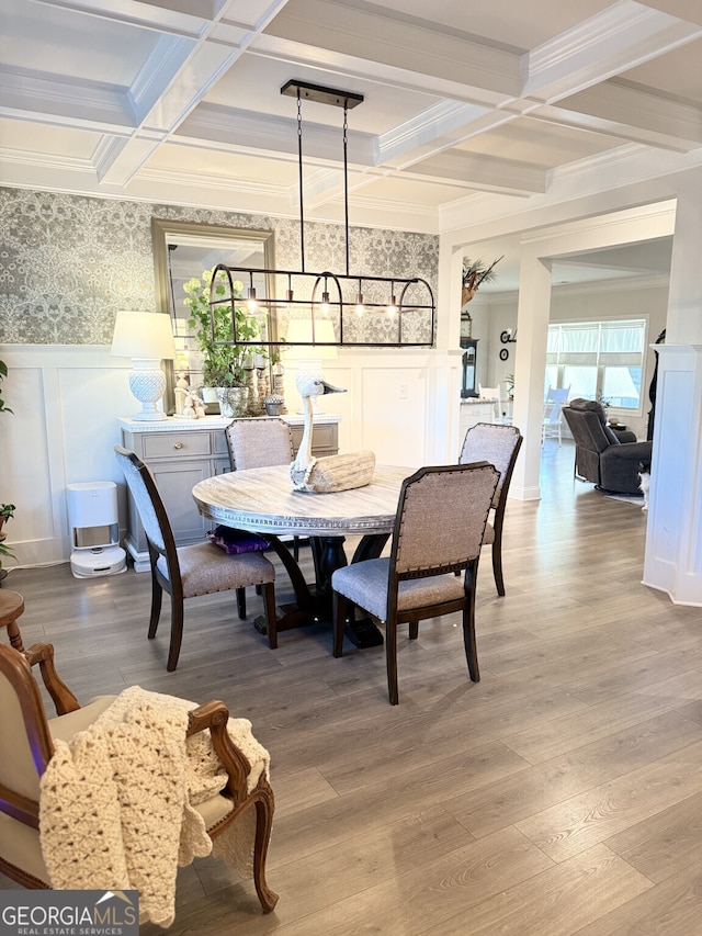 dining space with a decorative wall, coffered ceiling, beam ceiling, wood finished floors, and crown molding