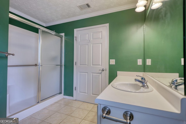 full bathroom featuring a shower with shower door, tile patterned floors, vanity, ornamental molding, and a textured ceiling
