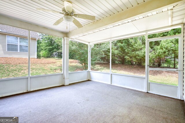 unfurnished sunroom featuring a ceiling fan and plenty of natural light