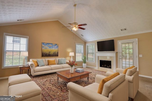 living area with baseboards, a ceiling fan, vaulted ceiling, a fireplace with flush hearth, and carpet floors