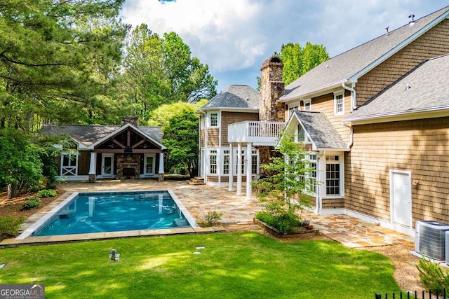 swimming pool featuring central AC unit, a patio, and a yard